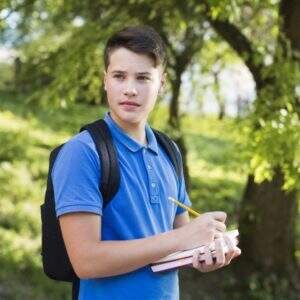 menino adolescente serio andando e escrevendo