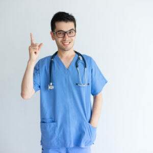 smiling young male doctor pointing upwards